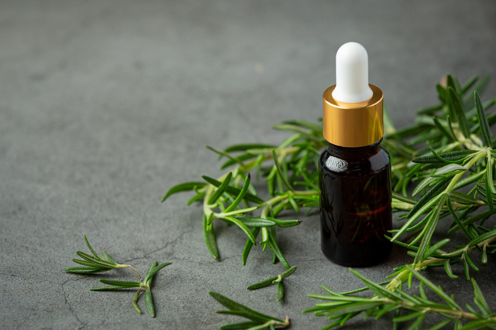 dried rosemary leaves with oil in a bottle